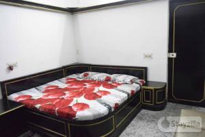 ein Schlafzimmer mit einem Bett mit roten Blumen darauf in der Unterkunft Sangleela in Neu-Delhi