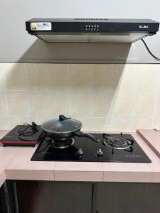 a pan sitting on top of a stove in a kitchen at JL Homestay Bahau in Bahau