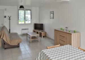 Televízia a/alebo spoločenská miestnosť v ubytovaní Maison de charme à Saint-Laurent-sur-Mer, vue sur mer et jardin