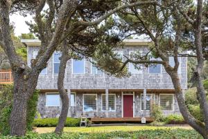 una casa con una porta rossa e alberi di Coastal Retreat with Ocean Views and Hot Tub a Newport