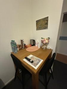 a wooden table with two chairs and a remote control on it at Chambre privée avec Clé in Beauvais