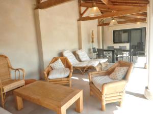 a living room with chairs and a table and a couch at Maison spacieuse à Soulac-sur-Mer avec jardin in Soulac-sur-Mer