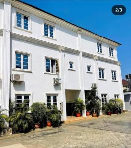 un grande edificio bianco con piante di fronte di The Tranquil Mews ad Abuja