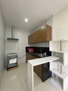 a kitchen with wooden cabinets and a counter top at Ciudad Ezperanza near Davao Airport in Davao City +18 photos