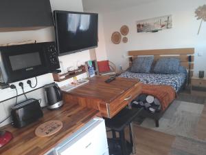 een keuken met een bureau en een bed in een kamer bij La petite maison studiot in Pornic
