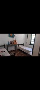 a room with a bed and a guitar in it at Camping Serra São José in Tiradentes