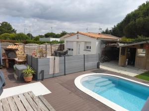 een achtertuin met een zwembad en een huis bij La petite maison studiot in Pornic