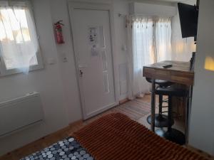 een kamer met een bureau, een tafel en een deur bij La petite maison studiot in Pornic