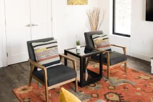 two chairs and a table in a living room at Riverfront Patio - Hot Tub - Luxe Silverthorne in Silverthorne