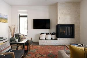 a living room with a fireplace and a tv at Riverfront Patio - Hot Tub - Luxe Silverthorne in Silverthorne