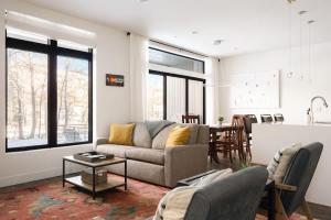 a living room with a couch and a table at Riverfront Patio - Hot Tub - Luxe Silverthorne in Silverthorne +37 photos