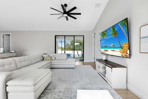 a living room with a white couch and a flat screen tv at Hidden Gem, Heated Pool & Spa - Enchanted El Dorado Retreat - Roelens in Bonita Springs