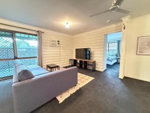 a living room with a couch and a television at Cute Cottage Home - Vintage Charm & Great Location at Slacks Creek, Close to Logan Central & M1 in Slacks Creek