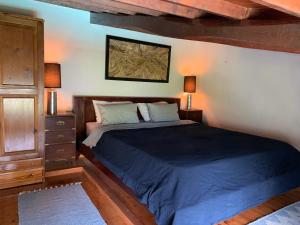 ein Schlafzimmer mit einem großen Bett mit blauer Bettwäsche in der Unterkunft Romantic Lemonia Cottage in Skopelos + 20 Fotos