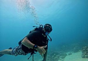 eine Person im Wasser mit Kamera in der Unterkunft Múcura Club Hotel in Isla Mucura