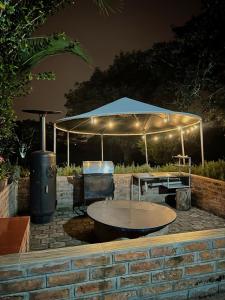 a patio with a table under a tent at night at Casa de huéspedes San Antonio in Hacienda La Merced +14 photos