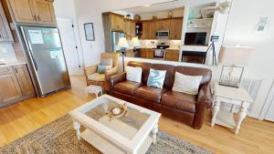a living room with a brown leather couch and a kitchen at Beautiful Sunrise in Folly Beach