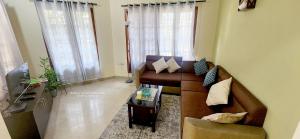 a living room with a couch and a table at Meadows Serene Retreat in Kannur