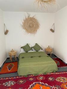 a bedroom with a bed and two tables on a rug at Chambre avec vue sur le océan in Wassane