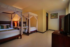 Postel nebo postele na pokoji v ubytování Adi Dharma Hotel Legian