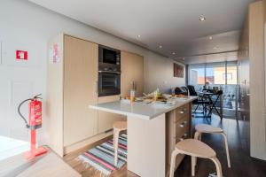 a kitchen with a counter and chairs in a room at H2O Apartment - Rooftop with pool in Santa Cruz in Santa Cruz