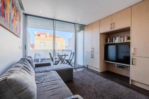 a living room with a couch and a tv at H2O Apartment - Rooftop with pool in Santa Cruz in Santa Cruz