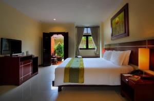 Postel nebo postele na pokoji v ubytování Adi Dharma Hotel Legian