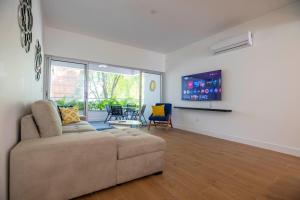 a living room with a couch and a flat screen tv at Perla Marina Beachside Apartment in Bombita