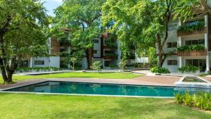 an apartment complex with a swimming pool in front of a building at Perla Marina Beachside Apartment in Bombita