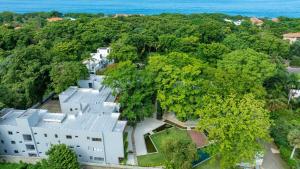 an aerial view of a white house with trees at Perla Marina Beachside Apartment in Bombita