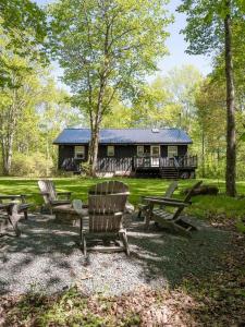 a cabin with picnic tables and chairs in front of it at Private Cabin with Guesthouse Hot Tub Fire Pits in Roscoe