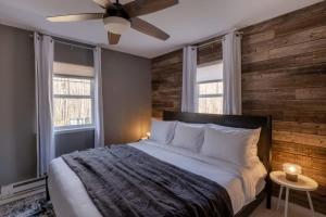 a bedroom with a bed with a wooden wall at Private Cabin with Guesthouse Hot Tub Fire Pits in Roscoe