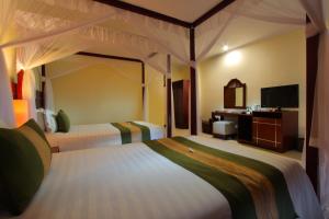 מיטה או מיטות בחדר ב-Adi Dharma Hotel Legian