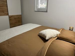 a bed with a pillow on it in a bedroom at Apartma - Hiša Zofija in Slovenske Konjice