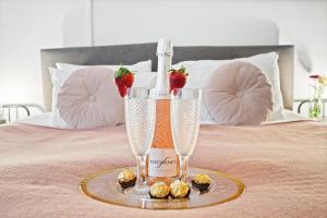 a bottle of champagne and strawberries on a bed at KGV Stays - Central Family Apartment, Sleeps 6, 7 Minute Walk to Beach, PET friendly in Bournemouth