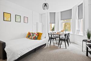 a room with a bed and a table with chairs at Spacious one bed Apartment, contractor friendly, Sleeps 6, FREE Secure Parking, Near Beach in Bournemouth