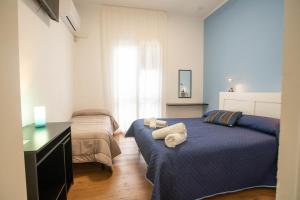 a bedroom with two beds and a desk and a window at Da Jaco in Castellammare del Golfo