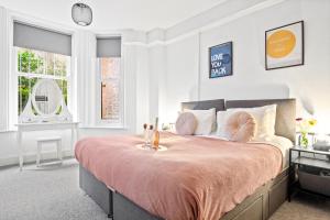 a bedroom with a large bed with a pink bedspread at Spacious one bed Apartment, contractor friendly, Sleeps 6, FREE Secure Parking, Near Beach in Bournemouth