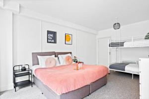 a bedroom with a large bed with a pink blanket at Spacious one bed Apartment, contractor friendly, Sleeps 6, FREE Secure Parking, Near Beach in Bournemouth +31 photos