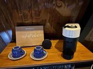 a coffee maker and two cups on a table at Montreal Cabanas in Poços de Caldas