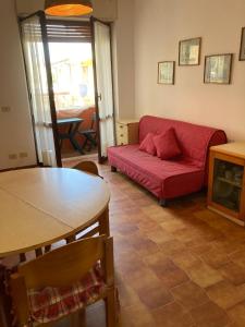 a living room with a red couch and a table at Casa vacanze Gio in La Maddalena