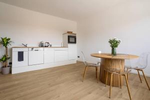 a kitchen and dining room with a table and chairs at Bright Suite I Sauna I TV I Kitchen in Gerolstein