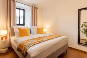 a bedroom with a large bed with yellow pillows at Tropical Wellness Suite I Sauna I Whirlpool I Hot Tub I TV I BBQ in Büdesheim