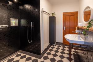 a bathroom with a shower and a sink at Tropical Wellness Suite I Sauna I Whirlpool I Hot Tub I TV I BBQ in Büdesheim +12 photos