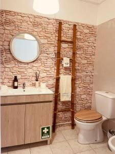 a bathroom with a stone wall with a sink and a toilet at Zambujeira Lounge in Zambujeira do Mar +45 photos