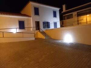 a building with lights on the side of it at night at Casa do Músico in Alverca +5 photos