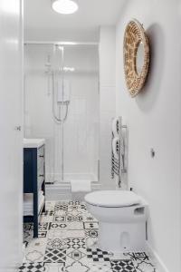 a white bathroom with a toilet and a shower at Harbour sea views in town centre in Falmouth