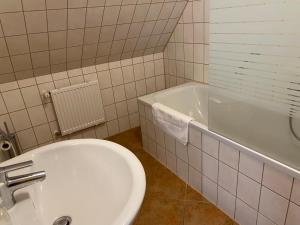 a bathroom with a toilet and a sink and a tub at Pension zum Zenshaus kleine Auszeit in Lychen +2 photos
