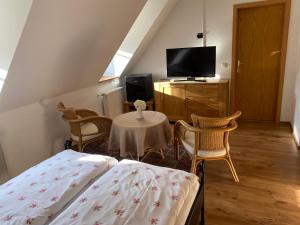 a bedroom with a bed and a table with chairs at Pension zum Zenshaus kleine Auszeit in Lychen