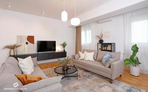 Una sala de estar con un sofá y un televisor. en Fancy 2BR Pipera Apartment, en Voluntari